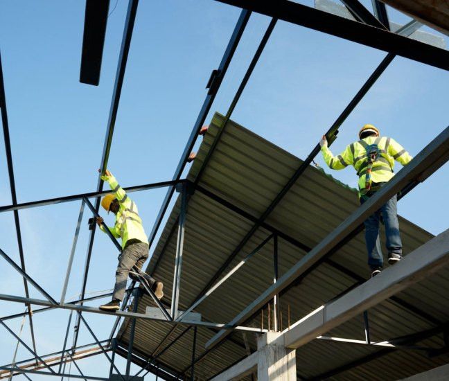 ACERO team working at height on a steel roof structure with safety equipment